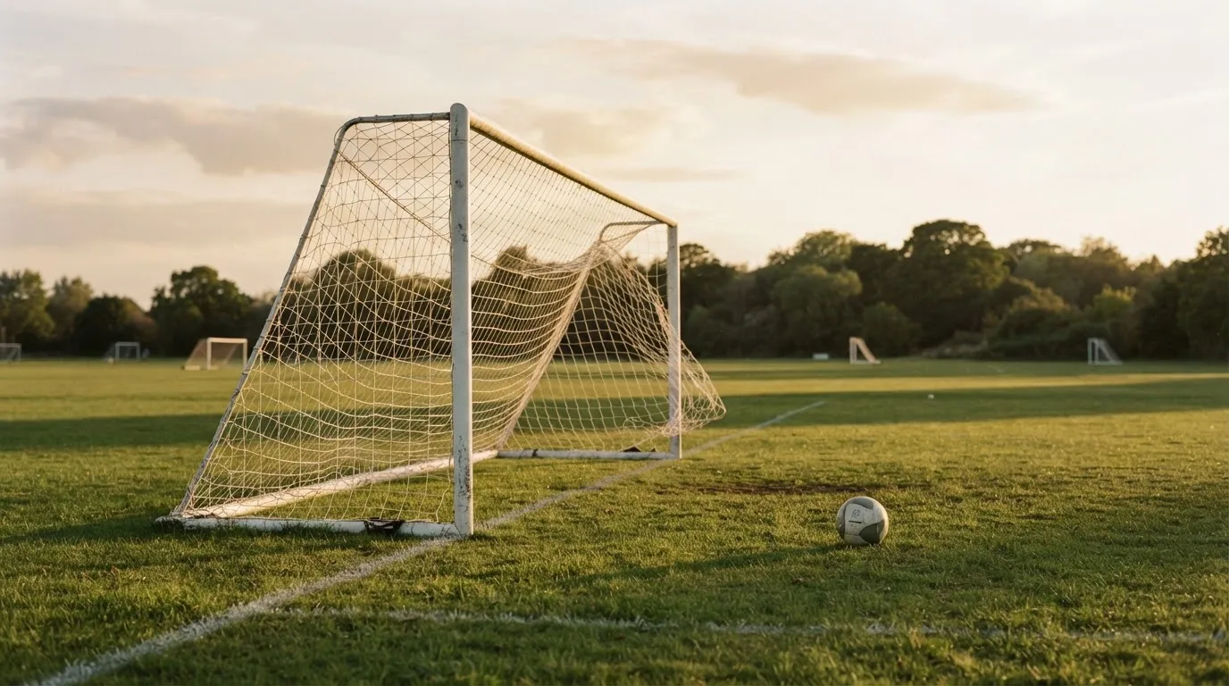 Ein Fussballtor mit locker hängendem Netz auf einem Trainingsplatz, das sich leicht im Wind bewegt.